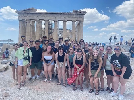 Students posing in a group in front of ruins in Greece.